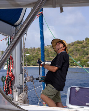 Man on boat, looking up holding adapted drill.