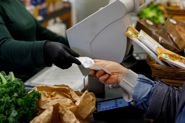 Person Receives Receipt at Grocery Store Checkout Counter