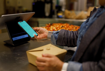 Woman Using Phone for paying at a Restaurant