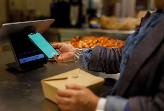 Woman Using Phone for paying at a Restaurant