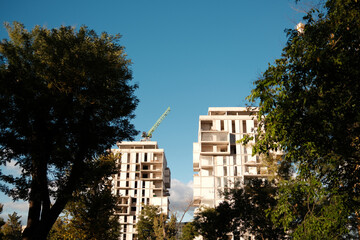 The process of building a multistoried house with a crane near the park