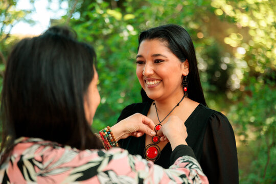 Woman Smiling While Trying On a Red Handmade Necklace