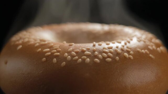 Closeup of a freshly baked sesame bagel with steam rising perfect for breakfast or snack. 4k Food Footage Video