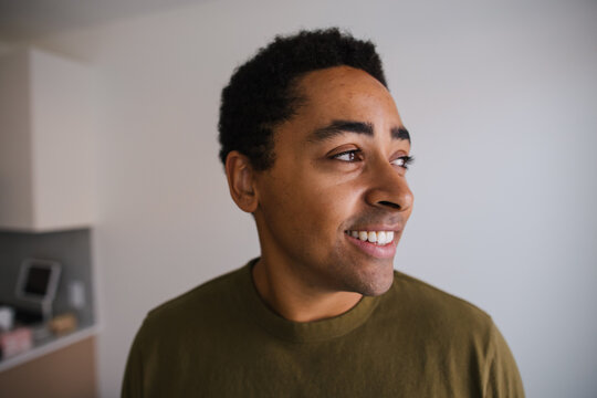 Candid portrait of a smiling man in a casual olive shirt indoors
