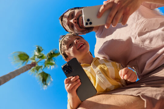 Father and Son Taking a Selfie Under Blue Sky