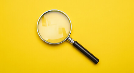 Magnifying glass on a bright yellow background, symbolizing research and discovery