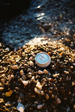 Beer can buried in pebbles
