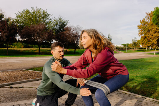 Geriatric trainer helps elderly woman improve her physical strength