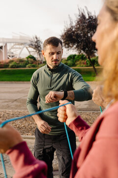 Personal trainer monitors an active elderly couple's workout