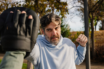 Senior trains his strength and coordination by practicing martial arts