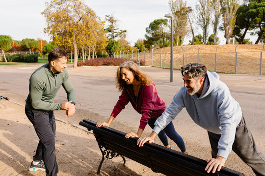 Wide shot of an older couple doing full-body strength exercises