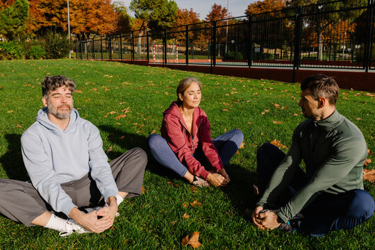 Elderly couple taking part in a meditation session on the grass
