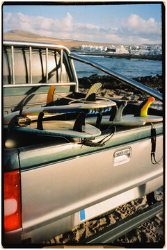 Analog shot of a pickup truck loaded with surfboards in the back