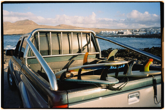 Pickup truck with surfboards stacked in its trunk during sunset