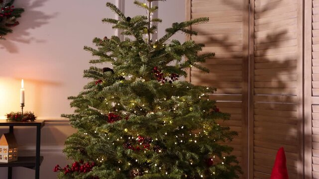 Beautiful Christmas tree and other festive decor indoors. Camera moving down