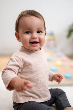 Close-Up Of Smiling Baby Sitting Indoors
