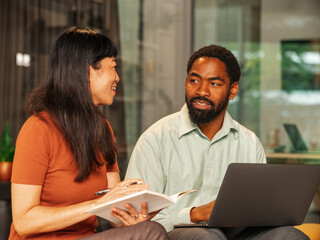 Two Friends Collaborating In a Modern Office Space With Laptop 