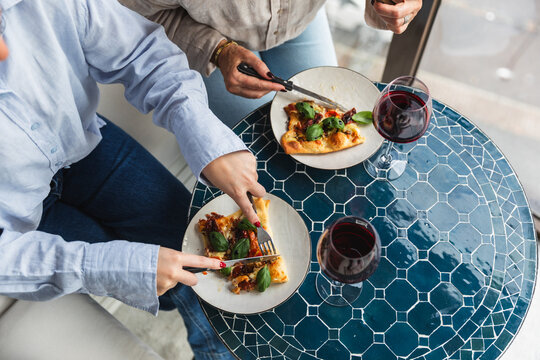High Angle View of Friends Sharing Homemade Pizza and Wine