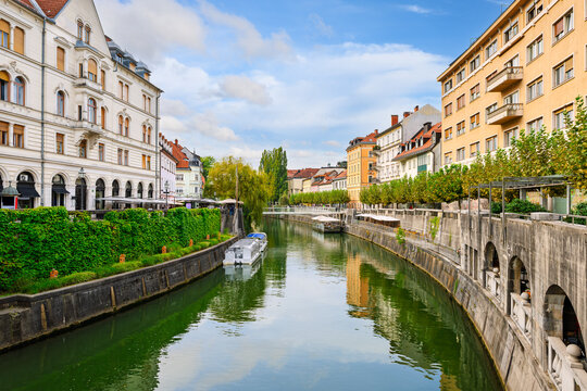 Boats wait for tourists on the Ljubljanica River between the cafes and shops along the Breg Embankment and Cankar Embankment in the old town center of Ljubljana, Slovenia.