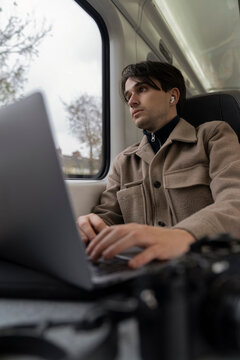 Young Man Studies on Train While Enjoying the View