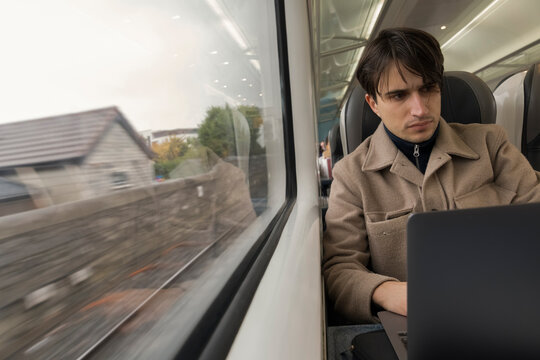 Student Working on Laptop While Commuting by Train