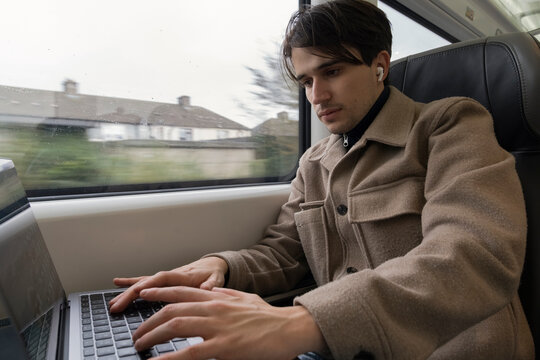 Young Man Studies on Train While Enjoying the View