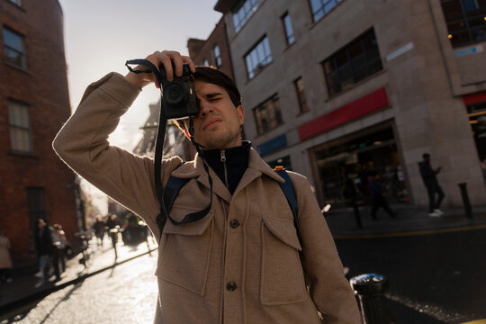 Young Man Capturing Street Scenes in Dublin's Vibrant Atmosphere