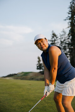 Candid moment of a woman golfer preparing for a shot on the course