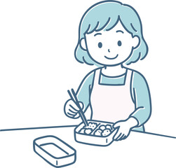 お弁当を詰めるエプロン姿の女性