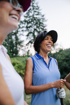 Candid outdoor laughter among friends during a sunny golf day