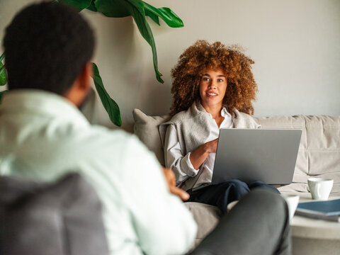Relaxed Office Lounge Conversation Between Colleagues Over Laptop 