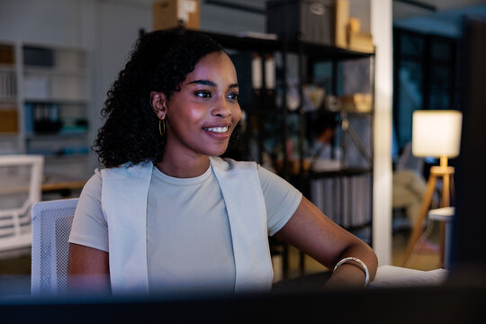 Smiling woman works at desk in office setting.