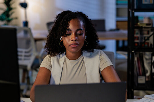 Woman working on laptop in office setting.