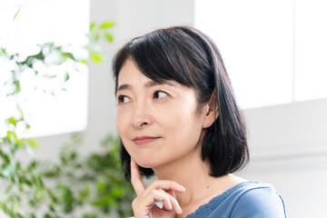 ソファーに座っているミドル女性　ライフスタイルイメージ