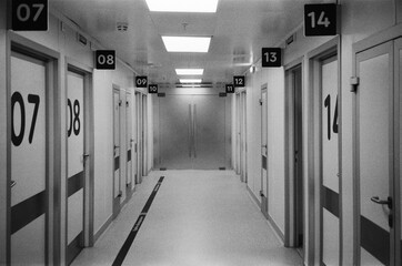 Long corridor lined with numbered doors in a modern medical facility