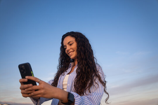 Woman Smiles While Using Smartphone 