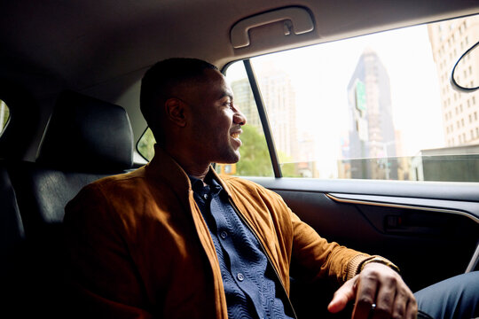 Cheerful man commutes by taxi