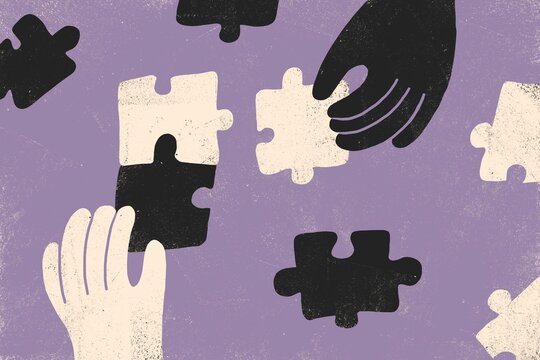 Black and white hands with puzzle pieces
