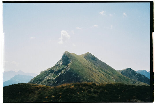 Film photo of a mountain peak under a clear blue sky