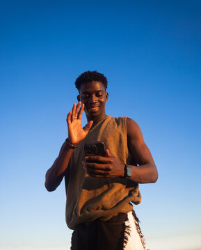 Young Man Smiling and Waving at the smartphone