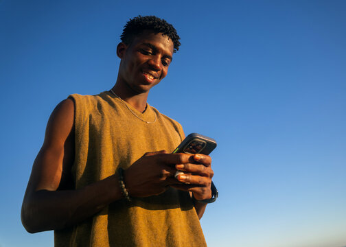 Smiling young man using smartphone