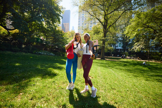 Female athletes snap selfies in the park.