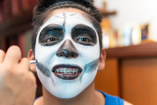 Boy getting skull makeup for dia de muertos