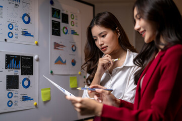 Businesswomen analyzing marketing data charts for company strategy