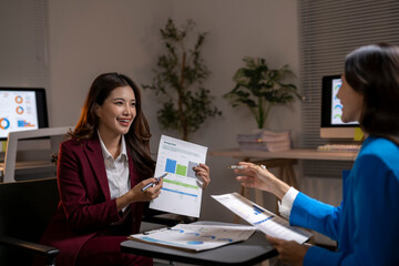 Businesswomen discussing sales data during office meeting