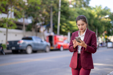 Asian businesswoman using smartphone on urban street