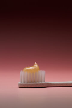 Close-up of a toothbrush with toothpaste on a gradient background