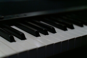 A close-up view of piano keys showing black and white keys under soft lighting. The image conveys a mood of music, creativity, art, and elegance