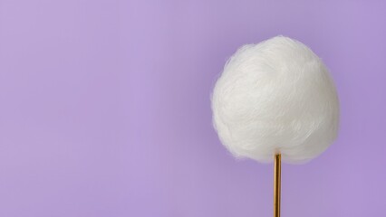 Single fluffy white cotton candy on a golden stick isolated against a solid lavender purple background, representing sweet nostalgia, carnival treats, and minimalist confectionery art.