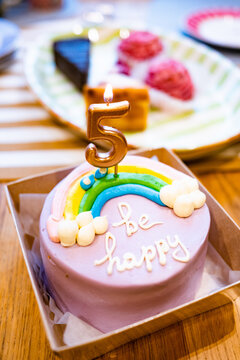 Celebration of a 5th birthday with a colorful cake